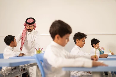 التربية والتعليم بالمناهج المقررة للتلاميذ،  جودة التعليم في السعودية، معلم عربي خليجي سعودي يرتدي الثوب التقليدي والشماغ يقوم بمناقشة الدروس مع طلابه، مجموعة من طلاب عربيين خليجيين سعوديين يرتدون الزي المدرسي يقومون بتأديه الواجبات ، المشاركة الفعالة للطلاب مع المدرسين،حوارات ودية بين الاستاذ والطلاب