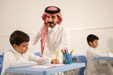 جودة التعليم في السعودية، معلم عربي خليجي سعودي يرتدي الثوب التقليدي والشماغ يقوم بمناقشة الدروس مع طلابه، مجموعة من طلاب عربيين خليجيين سعوديين يرتدون الزي المدرسي يقومون بتأديه الواجبات ، المشاركة الفعالة للطلاب مع المدرسين، التربية والتعليم بالمناهج المقررة للتلاميذ، حوارات ودية بين الاستاذ والطلاب