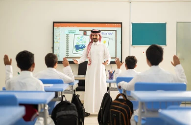 Gestures of enthusiasm to know the correct answer, participation and interaction within the classroom, Gulf Arab Saudi students sitting in their seats raising their hands to answer, education and teaching with the curricula prescribed for students in the Kingdom of Saudi Arabia.
