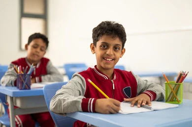 الإستعداد للعام الدراسي الجديد، التعليم في السعودية، تأدية الواجبات المدرسية، العودة إلى المدارس، مجموعة من الطلاب العربيين الخليجيين السعوديين يجلسون في مقاعدهم ويقومون بحل الواجب