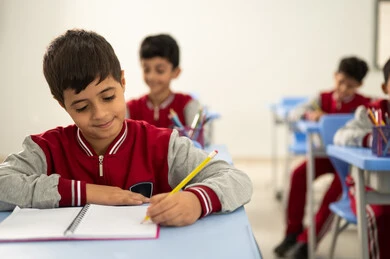 Preparation for the new school year, education in Saudi Arabia, completing school assignments, returning to school, a group of Arab Gulf Saudi students sitting in their seats and doing their homework.