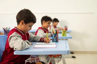 Preparation for the new school year, education in Saudi Arabia, completing school assignments, returning to school, a group of Arab Gulf Saudi students sitting in their seats and doing their homework.