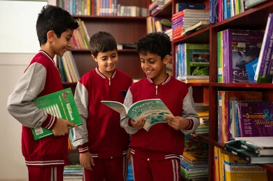 بيئه مدرسيه تعليميه متطوره ، مفهوم التعليم الذاتي,ممارسة هوايه المطالعة، مجموعة من طلاب عربيين خليجيين سعوديين يرتدون الزي المدرسي يجلسون في المكتبة المدرسية، الاستمتاع بقراءة الكتب المدرسية، التعليم في المملكة العربية السعودية