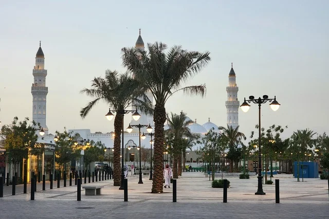The outdoor courtyard of Quba Mosque in Medina during the day, a call for Muslims to perform prayer and draw closer to Allah Almighty, landmarks and sacred religious places in the Kingdom of Saudi Arabia, the illuminated minarets and domes, architectural engineering art and Islamic decorations in a modern style.