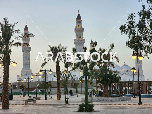 الساحة الخارجية لمسجد قباء في المدينة المنورة وقت النهار، دعوة المسلمين لآداء الصلاة والتقرب إلى الله تعالى، معالم وأماكن دينية مقدسة في المملكة العربية السعودية، المآذن و القبب المضيئة، الفن الهندسي المعماري والديكورات الاسلامية على الطراز الحديث