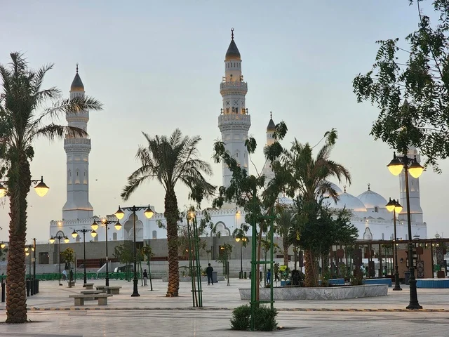 The outdoor courtyard of Quba Mosque in Medina during the day, a call for Muslims to perform prayer and draw closer to Allah Almighty, landmarks and sacred religious places in the Kingdom of Saudi Arabia, the illuminated minarets and domes, architectural engineering art and Islamic decorations in a modern style.