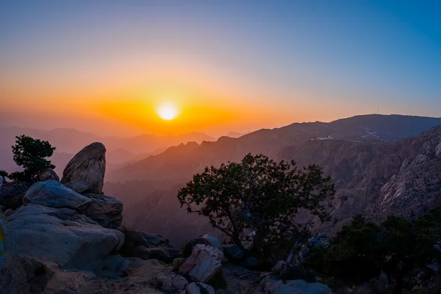 The breathtaking sunset over the Al-Shafa Mountains, Taif city, landmarks of the Kingdom of Saudi Arabia - a stunning mountainous view with a vibrant sky.