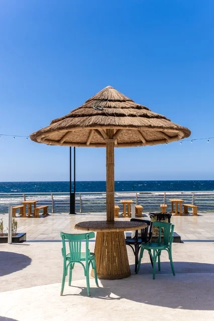 Parks on the waterfront, a charming daytime scene of Jeddah's beach and its distinctive landmarks, the meeting of the clear blue waters of the Red Sea with the wide horizon, a tranquil atmosphere reflecting the beauty of the city of Jeddah and the splendor of its coastal nature.
