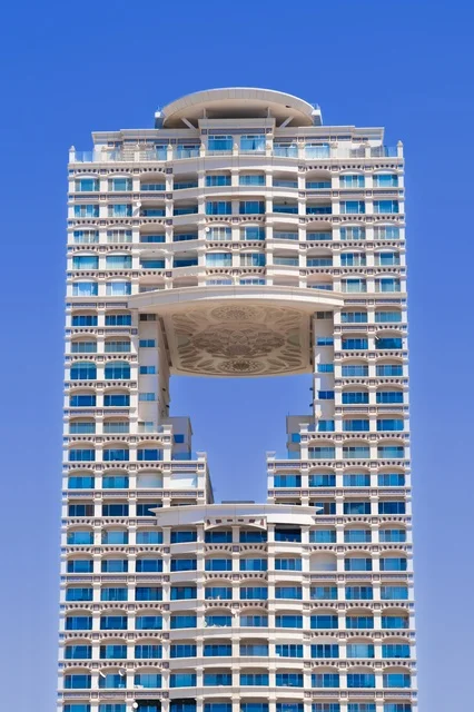 A magical daytime scene of Jeddah's beach and its distinctive landmarks, with mosques, hotels, and parks along the waterfront, creating a tranquil atmosphere that reflects the beauty of the city of Jeddah and the splendor of its coastal nature.