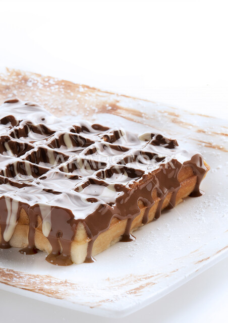 A plate of delicious waffles with liquid chocolate, coffee, sweets and sugars
