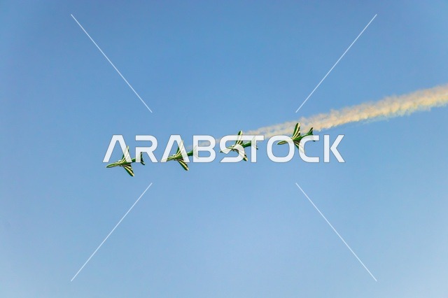 Aerial display of aircraft during the Saudi National Day celebrations on September 23, featuring recreational activities and events, a group of green Saudi planes flying in the blue sky of the Kingdom of Saudi Arabia.