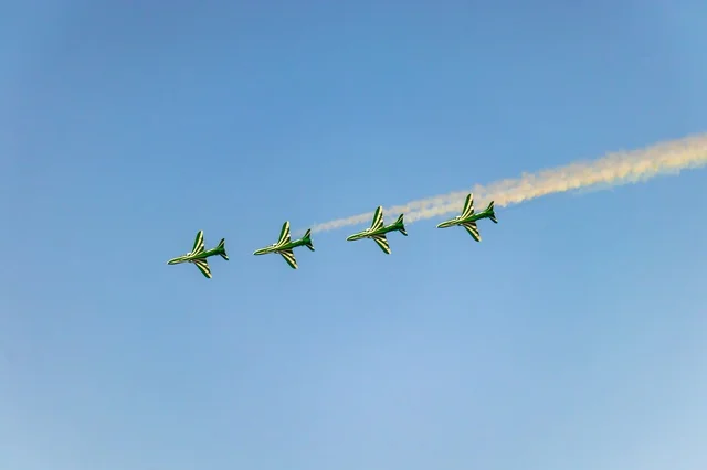 Aerial display of aircraft during the Saudi National Day celebrations on September 23, featuring recreational activities and events, a group of green Saudi planes flying in the blue sky of the Kingdom of Saudi Arabia.