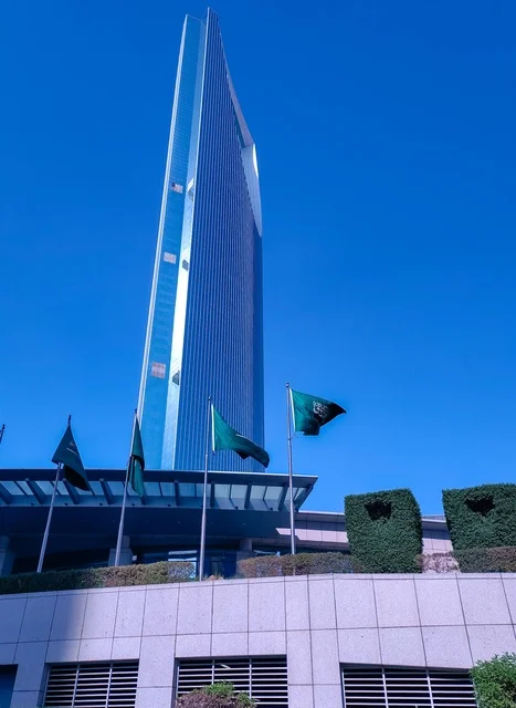 The Kingdom Tower building in Riyadh during the day, the architectural engineering art of building towers and skyscrapers in a modern style, famous landmarks and tourist places in the Kingdom of Saudi Arabia, the flags of the Kingdom fluttering on Saudi National Day, September 23.