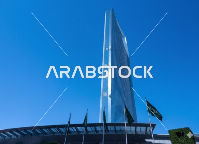 The Kingdom Tower building in Riyadh during the day, the architectural engineering art of building towers and skyscrapers in a modern style, famous landmarks and tourist places in the Kingdom of Saudi Arabia, the flags of the Kingdom fluttering on Saudi National Day, September 23.