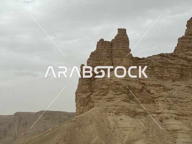 Natural archaeological tourist attractions in the Kingdom of Saudi Arabia, the desert nature, topography, and mountain peaks, mountain ranges in the Lower Najd region, rock formations and structures in the desert of Riyadh, the formation of dunes and sandy hills, the backdrop of nature.