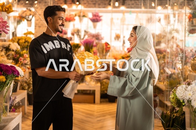 الاختفال بالأعياد والمناسبات الخاصة ، زوج عربي خليجي سعودي يرتدي الزي الكاجوال يقوم بإهداء باقة ورد اصفر طبيعي لزوجته، تعابير وايماءات المودة والسعاده، محلات ومتاجر بيع وشراء الورود والزهور الطبيعية
