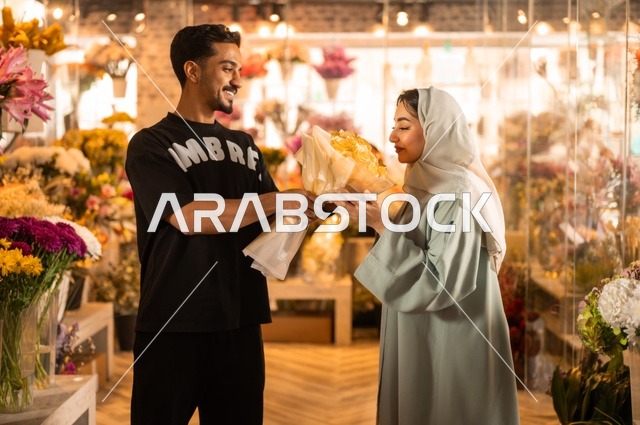 الاختفال بالأعياد والمناسبات الخاصة ، زوج عربي خليجي سعودي يرتدي الزي الكاجوال يقوم بإهداء باقة ورد اصفر طبيعي لزوجته، تعابير وايماءات المودة والسعاده، محلات ومتاجر بيع وشراء الورود والزهور الطبيعية