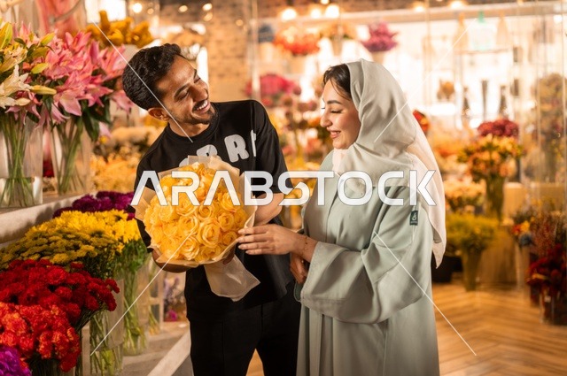 الاختفال بالأعياد والمناسبات الخاصة ، زوج عربي خليجي سعودي يرتدي الزي الكاجوال يقوم بإهداء باقة ورد اصفر طبيعي لزوجته، تعابير وايماءات المودة والسعاده، محلات ومتاجر بيع وشراء الورود والزهور الطبيعية