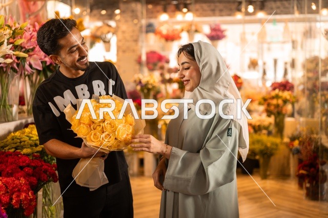 الاختفال بالأعياد والمناسبات الخاصة ، زوج عربي خليجي سعودي يرتدي الزي الكاجوال يقوم بإهداء باقة ورد اصفر طبيعي لزوجته، تعابير وايماءات المودة والسعاده، محلات ومتاجر بيع وشراء الورود والزهور الطبيعية