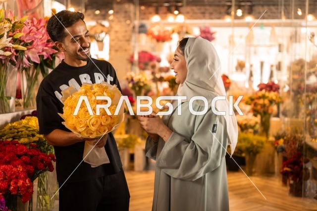 الاختفال بالأعياد والمناسبات الخاصة ، زوج عربي خليجي سعودي يرتدي الزي الكاجوال يقوم بإهداء باقة ورد اصفر طبيعي لزوجته، تعابير وايماءات المودة والسعاده، محلات ومتاجر بيع وشراء الورود والزهور الطبيعية