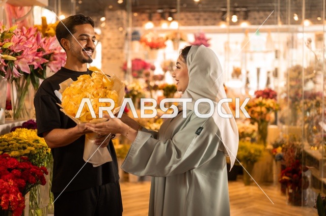 الاختفال بالأعياد والمناسبات الخاصة ، زوج عربي خليجي سعودي يرتدي الزي الكاجوال يقوم بإهداء باقة ورد اصفر طبيعي لزوجته، تعابير وايماءات المودة والسعاده، محلات ومتاجر بيع وشراء الورود والزهور الطبيعية