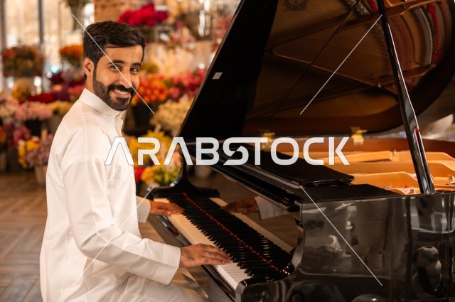 مواهب فنية موسيقية، قضاء الوقت بالعزف على الألات الوترية، الطرب والانشطة ترفيهية، تقديم البرامج والفنون الموسيقية والفن المسرحي، رجل خليجي سعودي عربي فنان يجلس امام آلة البيانو الموسيقية ويستمتع بالعزف