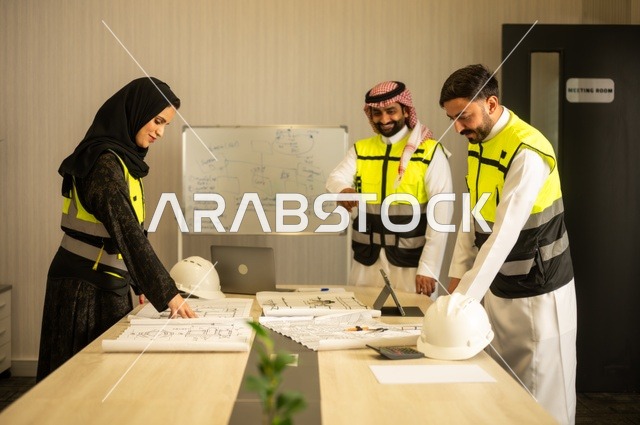 متابعة تنفيذ الخطط الهندسية الموضوعة، الشركات المختصة بورشات البناء والمقاولات، التخطيط ووضع المخططات المعمارية، مجموعة مهندسون عرب خليجيون سعوديون يعملون على مناقشة مخطط الإنشاء وتحديد القياسات بدقة داخل مقر الشركة