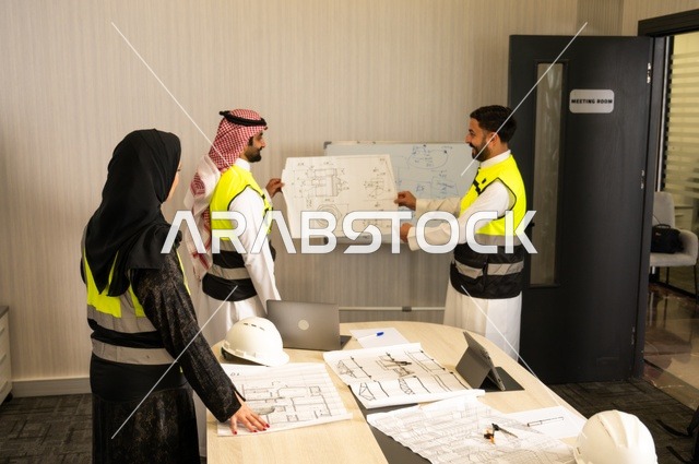 متابعة تنفيذ الخطط الهندسية الموضوعة، الشركات المختصة بورشات البناء والمقاولات، التخطيط ووضع المخططات المعمارية، مجموعة مهندسون عرب خليجيون سعوديون يعملون على مناقشة مخطط الإنشاء وتحديد القياسات بدقة داخل مقر الشركة