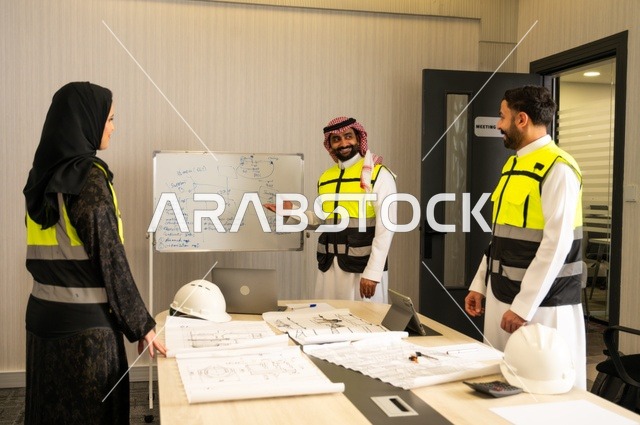 متابعة تنفيذ الخطط الهندسية الموضوعة، الشركات المختصة بورشات البناء والمقاولات، التخطيط ووضع المخططات المعمارية، مجموعة مهندسون عرب خليجيون سعوديون يعملون على مناقشة مخطط الإنشاء وتحديد القياسات بدقة داخل مقر الشركة