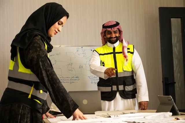 التخطيط ووضع المخططات المعمارية، مجموعة مهندسون عرب خليجيون سعوديون يعملون على مناقشة مخطط الإنشاء وتحديد القياسات بدقة داخل مقر الشركة، متابعة تنفيذ الخطط الهندسية الموضوعة، الشركات المختصة بورشات البناء والمقاولات