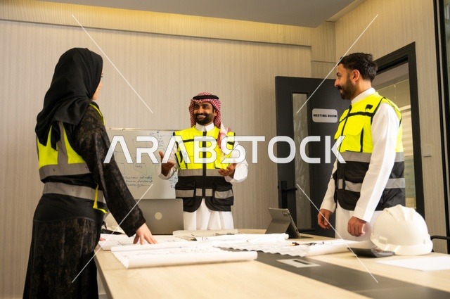 الشركات المختصة بورشات البناء والمقاولات، التخطيط ووضع المخططات المعمارية، مجموعة مهندسون عرب خليجيون سعوديون يعملون على مناقشة مخطط الإنشاء وتحديد القياسات بدقة داخل مقر الشركة، متابعة تنفيذ الخطط الهندسية الموضوعة