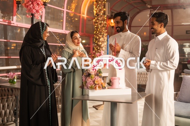 زينة الأعياد والمناسبات السعيدة، إيماءات السعادة والمفاجأة والفرح، أصدقاء عرب خليجيون سعوديون يقومون بالاحتفال بعيد ميلاد صديقتهم في إحدى المطاعم السعودية، قضاء وقت ممتع مع الأهل والأصدقاء، كعكة عيد ميلاد