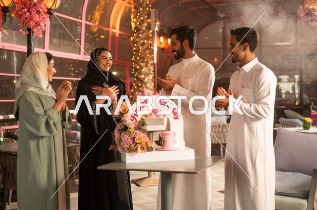 زينة الأعياد والمناسبات السعيدة، إيماءات السعادة والمفاجأة والفرح، أصدقاء عرب خليجيون سعوديون يقومون بالاحتفال بعيد ميلاد صديقتهم في إحدى المطاعم السعودية، قضاء وقت ممتع مع الأهل والأصدقاء، كعكة عيد ميلاد