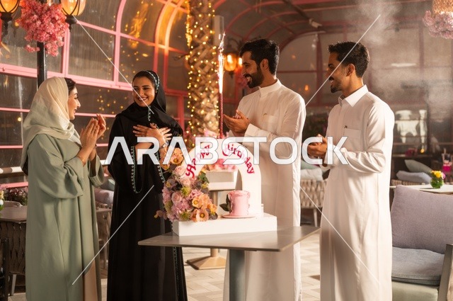 إيماءات السعادة والمفاجأة والفرح، زينة الأعياد والمناسبات السعيدة، أصدقاء عرب خليجيون سعوديون يقومون بالاحتفال بعيد ميلاد صديقتهم في إحدى المطاعم السعودية، قضاء وقت ممتع مع الأهل والأصدقاء، كعكة عيد ميلاد