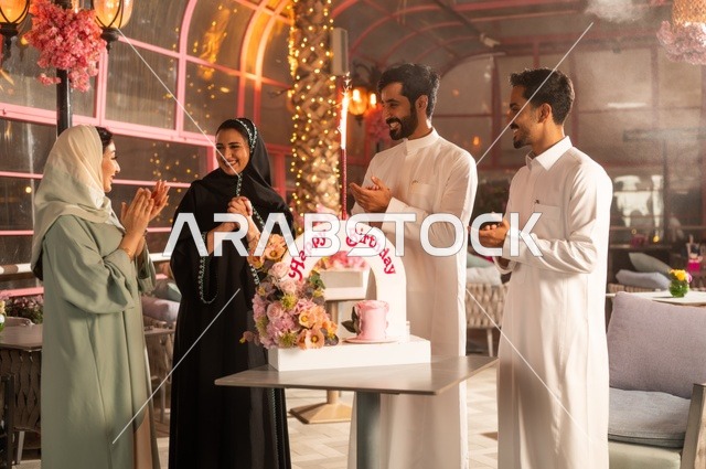 زينة الأعياد والمناسبات السعيدة، إيماءات السعادة والمفاجأة والفرح، أصدقاء عرب خليجيون سعوديون يقومون بالاحتفال بعيد ميلاد صديقتهم في إحدى المطاعم السعودية، قضاء وقت ممتع مع الأهل والأصدقاء، كعكة عيد ميلاد
