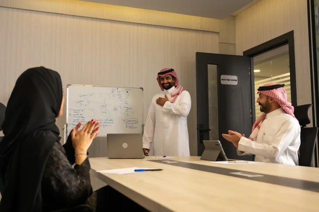 ايماءات التشجيع والتصفيق،  استخدام اللابتوب في تدوين الملاحظات، ضمان فهم واضح وشامل للاعمال، استعمال السبورة لتوضيح العمليات والاجراءات المتبعة في الشركة، العمل الجماعي وروح الفريق، الاحترافية والتفاني في الإنجاز، فريق عربي خليجي سعودي في اجتماع داخل المكتب