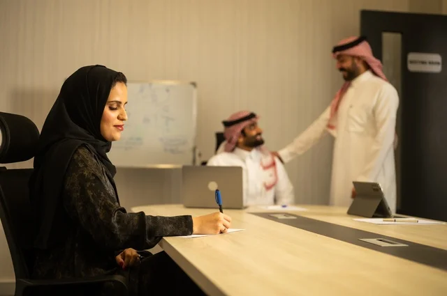 Teamwork and team spirit, discussing work plans, using laptops to take notes, professionalism and dedication to achievement, a Saudi Gulf Arab team in a meeting inside the office, ensuring a clear and comprehensive understanding of the work, clarifying the processes and procedures followed in the company.