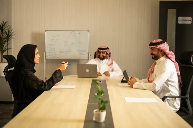 العمل الجماعي وروح الفريق، مناقشة خطط العمل، استخدام اللابتوب في تدوين الملاحظات، الاحترافية والتفاني في الإنجاز، فريق عربي خليجي سعودي في اجتماع داخل المكتب، ضمان فهم واضح وشامل للاعمال، توضيح العمليات والاجراءات المتبعة في الشركة