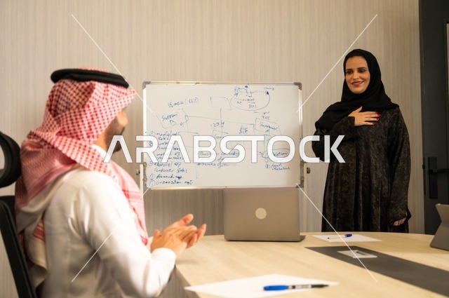 العمل الجماعي وروح الفريق، مناقشة خطط العمل، استخدام اللابتوب في تدوين الملاحظات، الاحترافية والتفاني في الإنجاز، فريق عربي خليجي سعودي في اجتماع داخل المكتب، ضمان فهم واضح وشامل للاعمال، توضيح العمليات والاجراءات المتبعة في الشركة