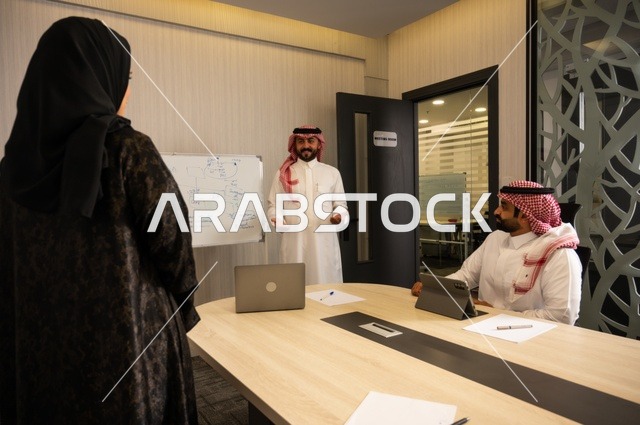 العمل الجماعي وروح الفريق، مناقشة خطط العمل، استخدام اللابتوب في تدوين الملاحظات، الاحترافية والتفاني في الإنجاز، فريق عربي خليجي سعودي في اجتماع داخل المكتب، ضمان فهم واضح وشامل للاعمال، توضيح العمليات والاجراءات المتبعة في الشركة
