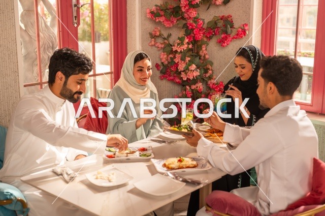 الاستمتاع بتناول الغداء في المطعم, جلسة وناسة وتعارف، بناء علاقات اجتماعية ناجحة, تبادل الأحاديث والاخبار, مشاركة الأصدقاء الأوقات الممتعة, عائلة عرب خليجيون سعوديون يجلسون على المائدة في إحدى المطاعم الراقية ويقومون بتناول الطعام بإيماءات السعادة والسرور