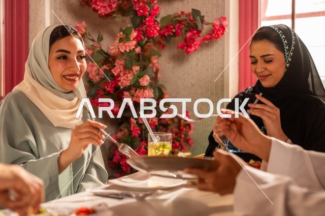 الاستمتاع بتناول الغداء في المطعم, جلسة وناسة وتعارف، بناء علاقات اجتماعية ناجحة, تبادل الأحاديث والاخبار, مشاركة الأصدقاء الأوقات الممتعة, عائلة عرب خليجيون سعوديون يجلسون على المائدة في إحدى المطاعم الراقية ويقومون بتناول الطعام بإيماءات السعادة والسرور