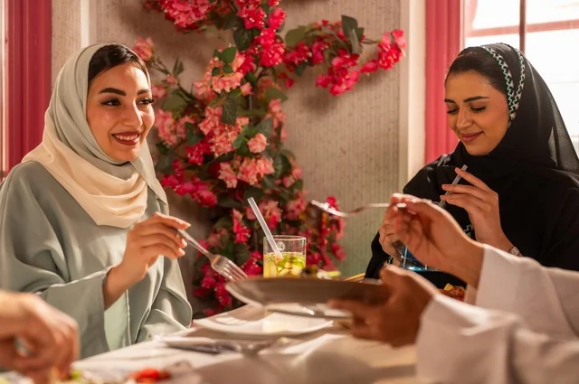 الاستمتاع بتناول الغداء في المطعم, جلسة وناسة وتعارف، بناء علاقات اجتماعية ناجحة, تبادل الأحاديث والاخبار, مشاركة الأصدقاء الأوقات الممتعة, عائلة عرب خليجيون سعوديون يجلسون على المائدة في إحدى المطاعم الراقية ويقومون بتناول الطعام بإيماءات السعادة والسرور