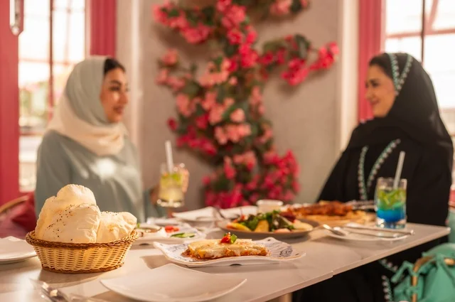 A luxurious restaurant in the kingdom, delicious food and meals, engaging in enjoyable conversations among friends, a fun and social gathering, Arab Gulf Saudi friends sitting in one of the upscale restaurants having lunch, building social relationships, spending enjoyable times with friends, a meeting on the weekend.