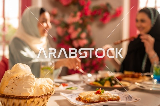 Delicious dishes and meals, having an enjoyable conversation among friends, a fun and social gathering, Arab Gulf Saudi friends sitting in a luxurious restaurant having lunch, building social relationships, spending enjoyable times with friends, an upscale restaurant in the kingdom, a meeting on the weekend.