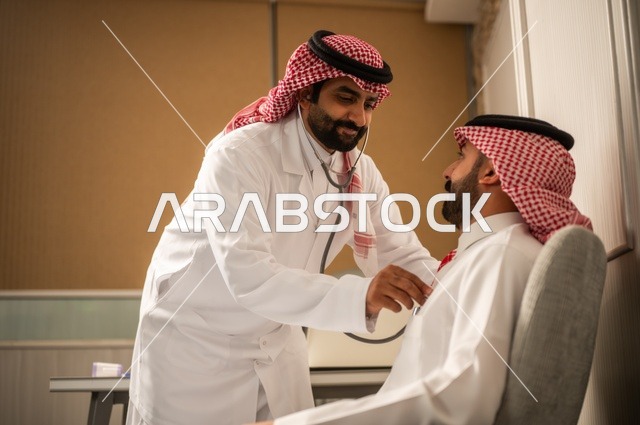 قياس  معدل ضربات القلب, مفهوم الطب والرعاية الصحية, المتابعة الدورية لفحص نبضات القلب, طبيب عربي خليجي سعودي يرتدي المعطف الطبي يقوم باستخدام سماعه الفحص الطبية لمريض يرتدي الشماغ والثوب التقليدي