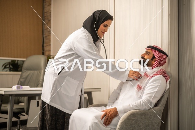 قياس  معدل ضربات القلب, مفهوم الطب والرعاية الصحية, المتابعة الدورية لفحص نبضات القلب, طبيب عربي خليجي سعودي يرتدي المعطف الطبي يقوم باستخدام سماعه الفحص الطبية لمريض يرتدي الشماغ والثوب التقليدي