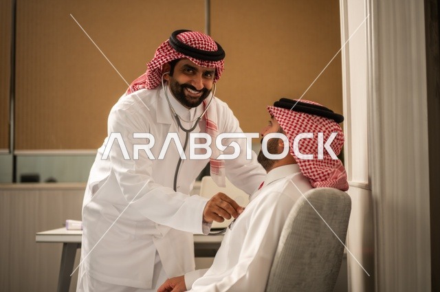 قياس  معدل ضربات القلب, مفهوم الطب والرعاية الصحية, المتابعة الدورية لفحص نبضات القلب, طبيب عربي خليجي سعودي يرتدي المعطف الطبي يقوم باستخدام سماعه الفحص الطبية لمريض يرتدي الشماغ والثوب التقليدي