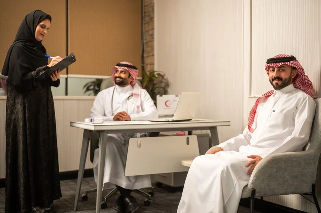 Monitoring the medical records of patients, assistance in recording patient cases, an Arab Gulf Saudi doctor wearing a white coat explaining the medical condition to a patient wearing a ghutrah and traditional thobe, dialogue with patients to uncover the condition, providing consultations in medical centers, working in the health sectors.