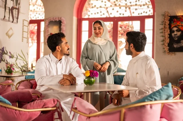 احتساء المشروب المفضل في كوفي شوب، قضاء أوقات ممتعة مع الأصدقاء، تطوير علاقات اجتماعية ناجحة بين الأشخاص،النقاش والحوار في الأجواء الهادئة، صورة لزملاء عربيين خليجيين سعوديين مبتسمين يجلسون في إحدى المقاهي الراقية بتعابير السعادة والسرور